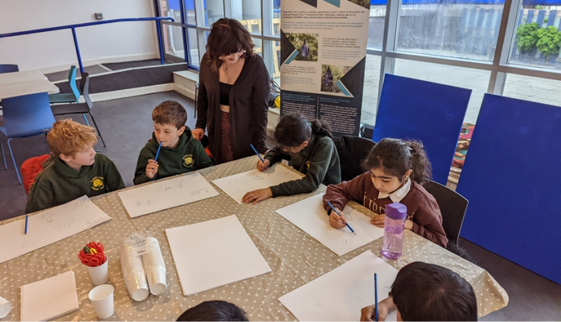 Figure 2: Izzy assisting pupils from Parkland Primary with their collage drawings